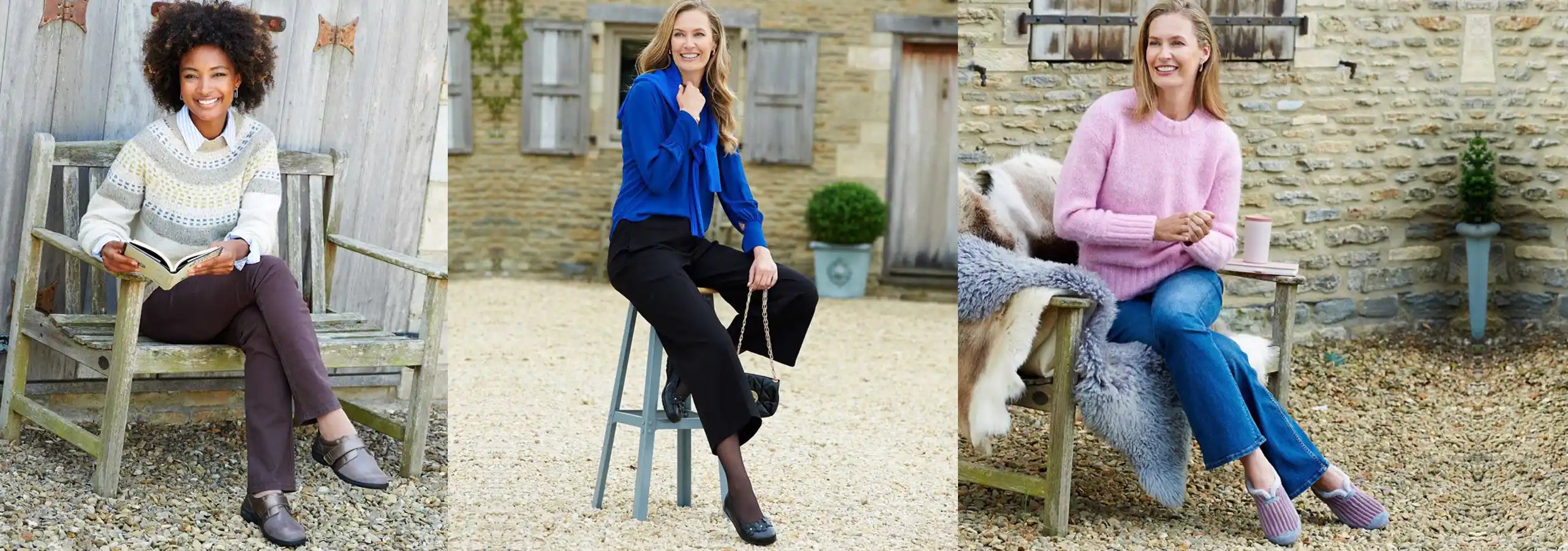 Three women sitting outdoors in a rustic setting, wearing colorful sweaters.